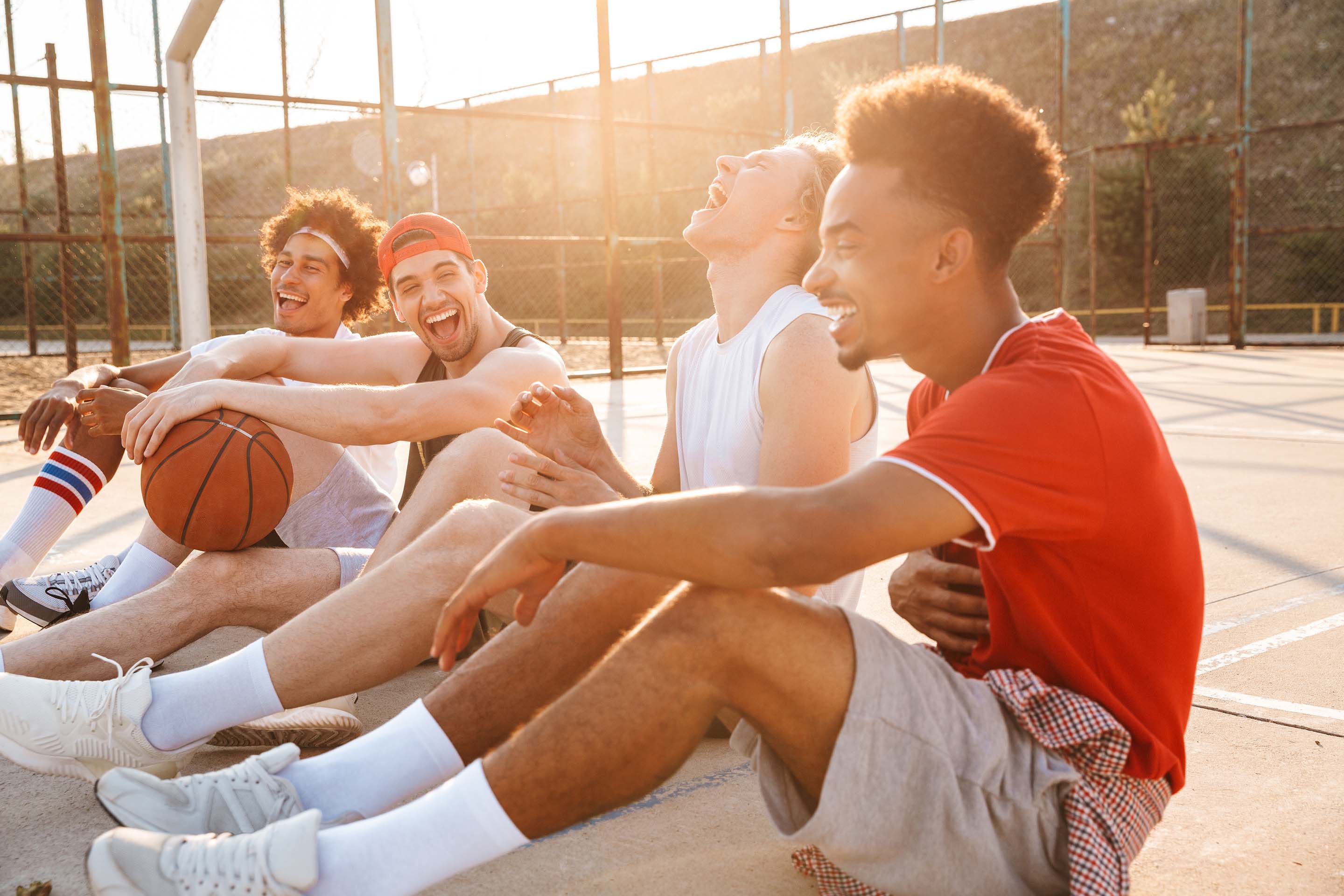 group of friends laughing after playing basketball